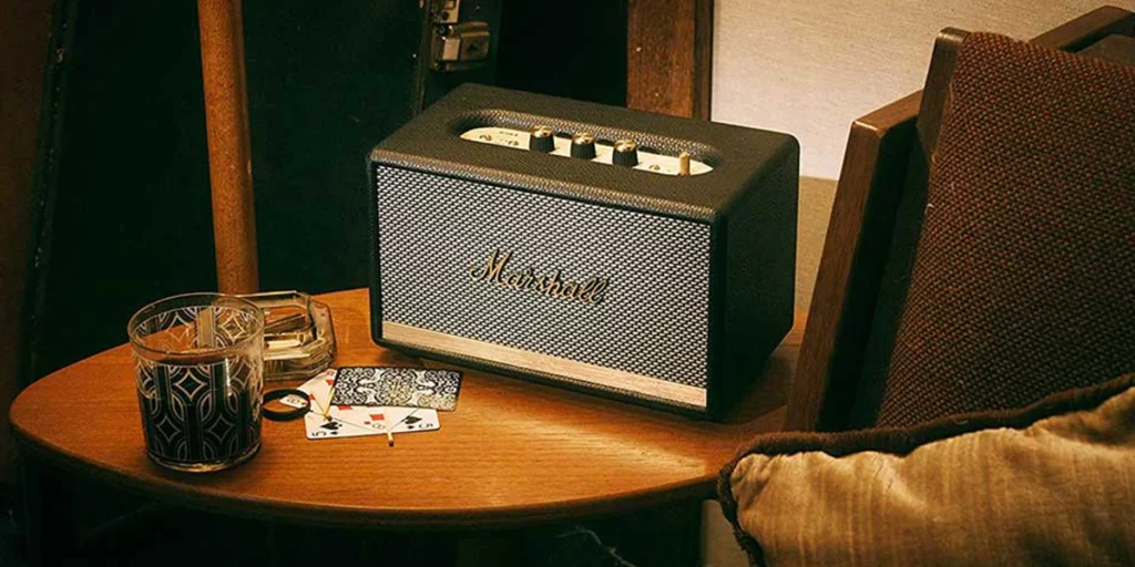 Enceinte Bluetooth Marshall Acton II posée sur une table en bois dans un salon vintage