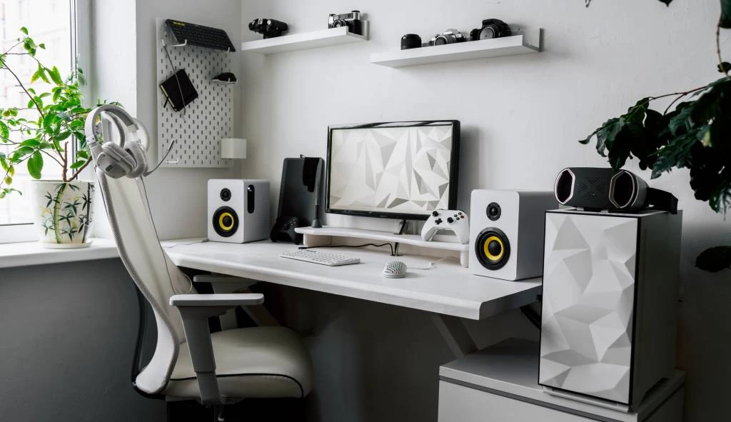 Bureau épuré avec éléments décoratifs, plantes vertes, étagères murales et accessoires de streaming sur fond blanc